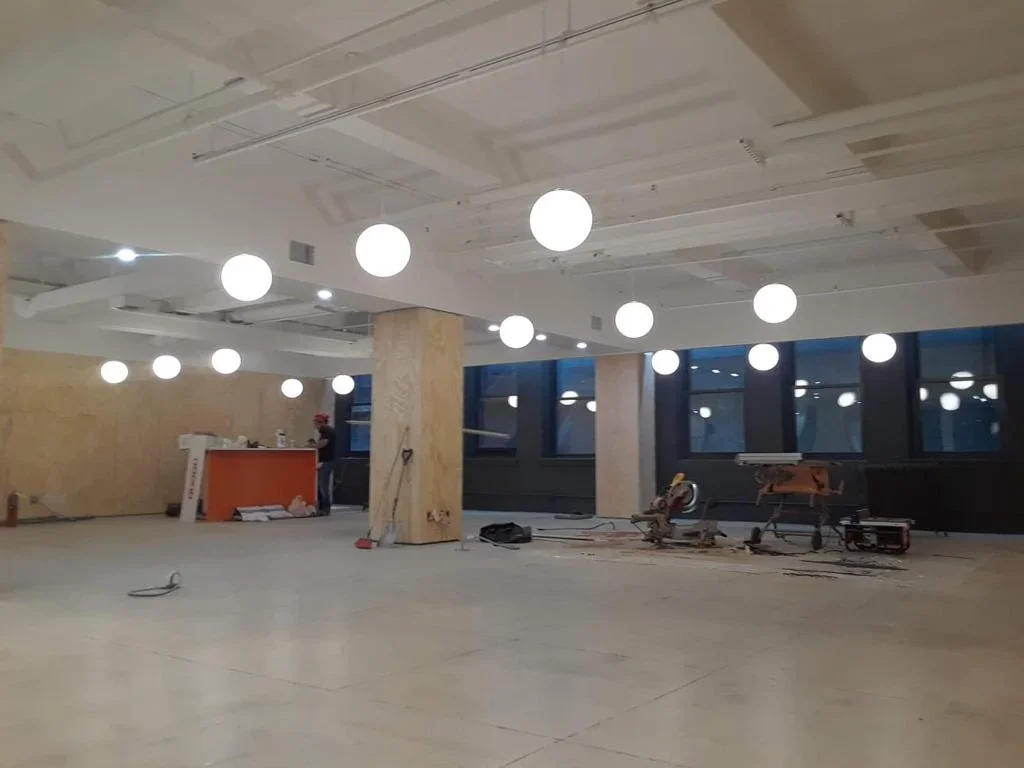 Commercial HVAC installation with modern LED lighting in open office space