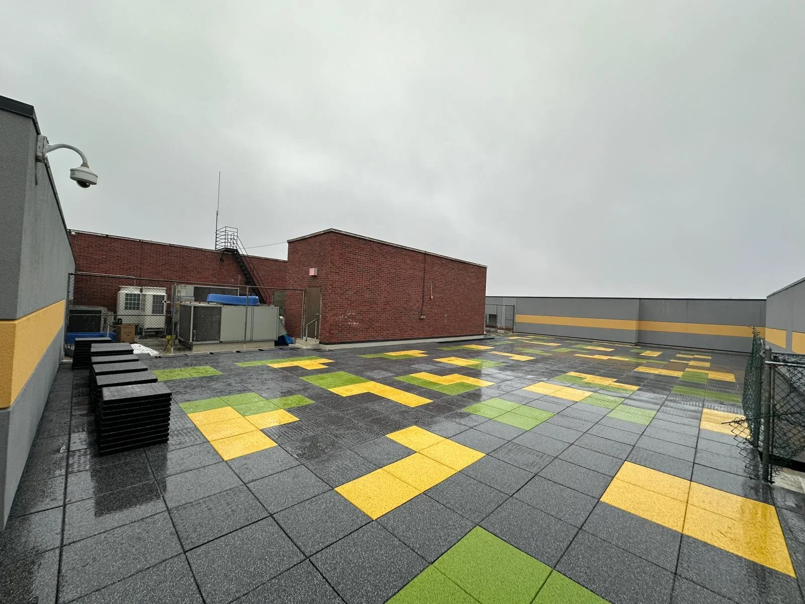 Commercial rooftop with installed HVAC units and colorful safety tile decking