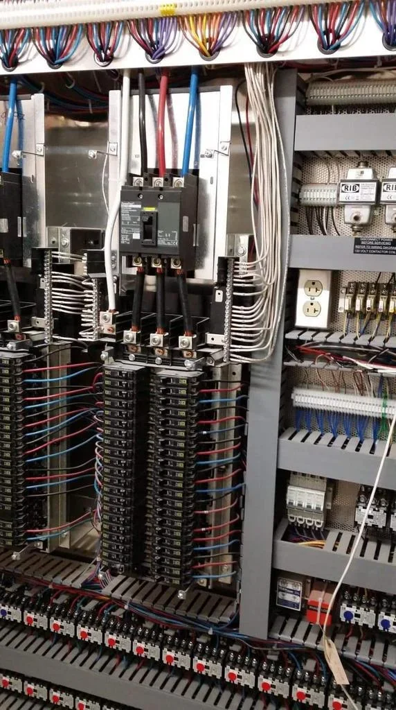 Commercial electrical panel with dual breakers, organized circuits, and color-coded wiring