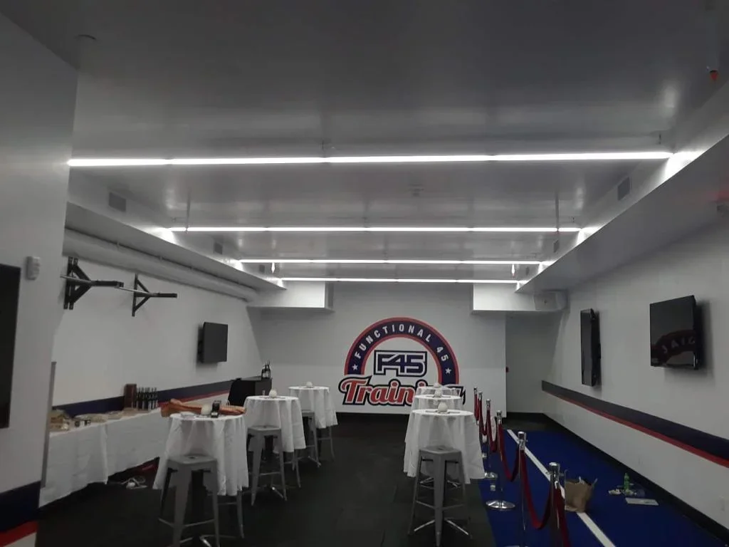 Commercial HVAC installation with linear LED ceiling and integrated ductwork in fitness facility