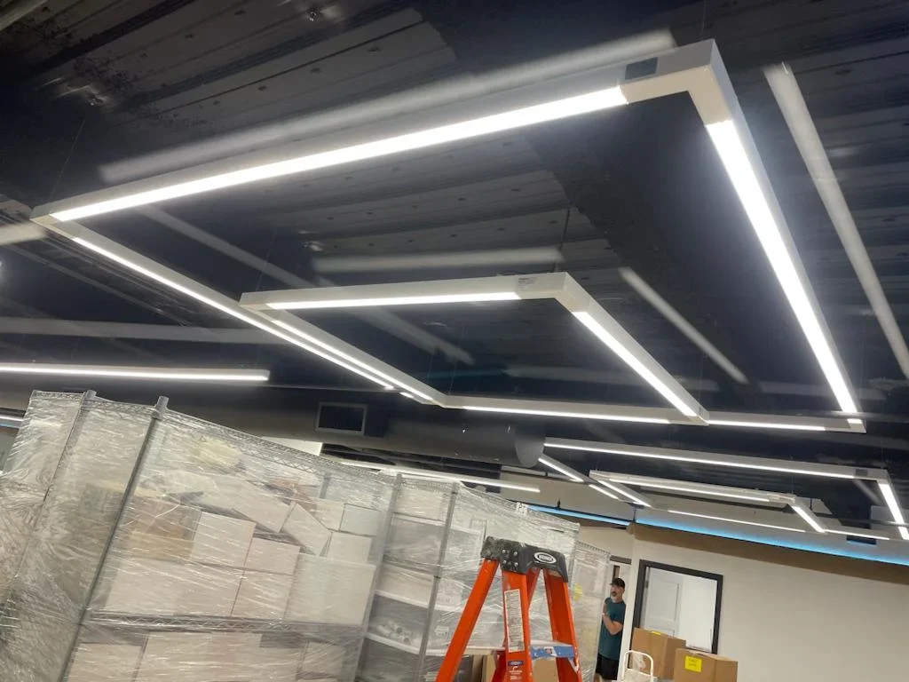 Recessed linear LED ceiling lights installed in geometric pattern with white trim